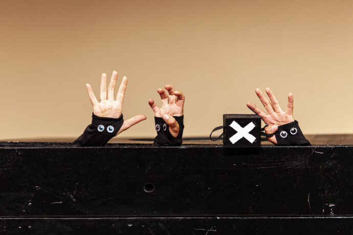 Foto voorstelling Boef, drie handjes met oogjes boven een tafel